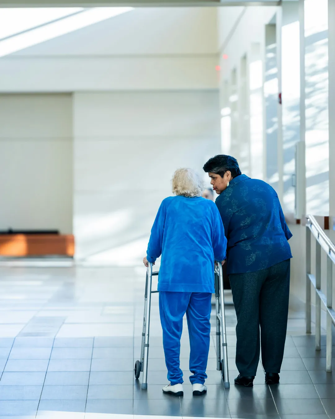 caregiver and elderly person walking